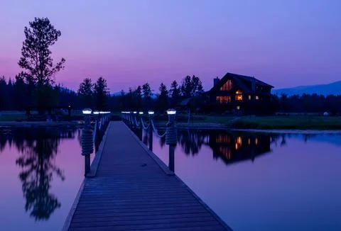 Step onto the pier and behold the rustic charm of a wooden log house 库存照片