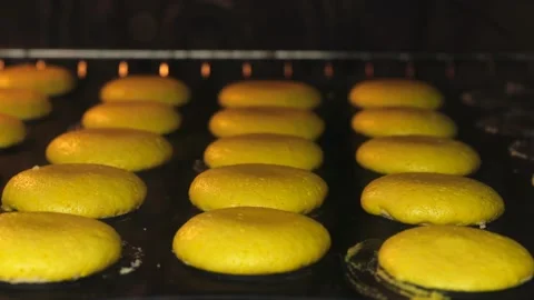 Step by step bake macaron. yellow   airy dough is baked in the oven Stock Footage 238899811