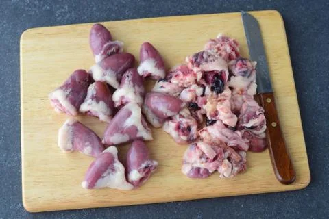 Step by step cooking. Raw cleaned chicken hearts on a wooden cutting board Stock Photos