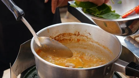 Step by step cooking tom yam soup. Spicy chili peppers and herbs are added to Stock Footage 106657926