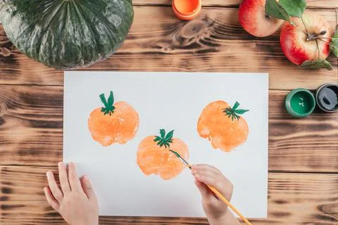 Step-by-step Halloween tutorial pumpkin apple prints. Step 9: Child hand draw Foto stock