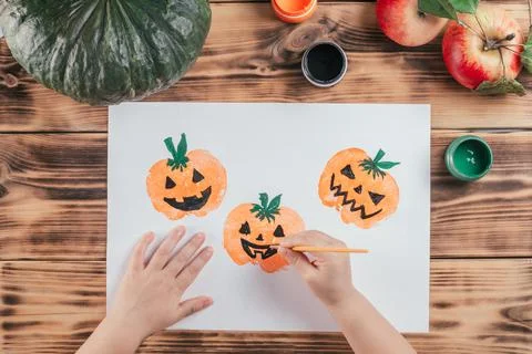 Step-by-step Halloween tutorial pumpkin apple prints. Step 10: Child hand dra Stock Photos