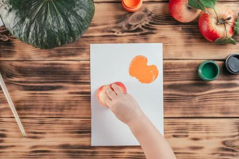 Step-by-step Halloween tutorial pumpkin apple prints. Step 8: Child hand leav Stock Photos