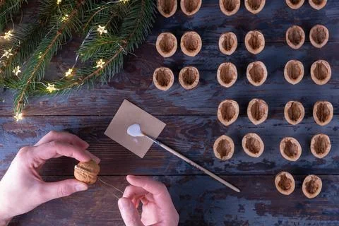 Step-by-step instructions: DIY golden nut tree toy. Step 9: firmly squeeze th Stock Photos