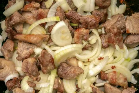 Step-by-step process of cooking pilaf in a cast iron cauldron Stock Photos