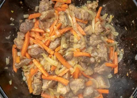 Step-by-step process of cooking pilaf in a cast iron cauldron Foto stock