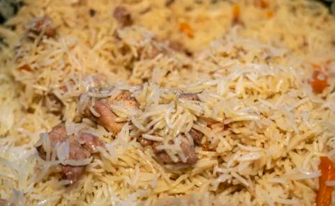 Step-by-step process of cooking pilaf in a cast iron cauldron Stock Photos