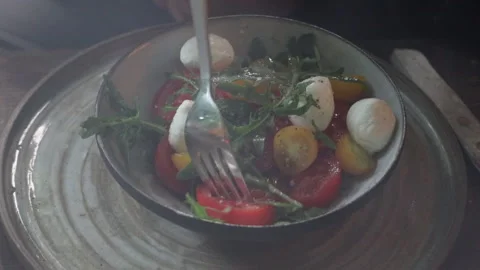 Step-by-step process for making tomato and cheese salad in a ceramic bowl	 Vídeos de archivo 280405922