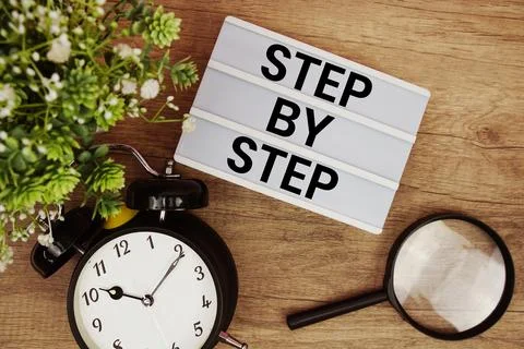 Step By Step text in lightbox with magnifying glass and alarm clock flat la.. Stock Photos