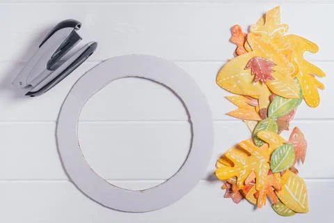 Step-by-step tutorial autumn paper wreath. Step 4: use stapler to fix leaves  Stock Photos