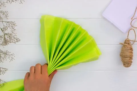 Step by step tutorial on making a light green fluffy pom-pom from tissue pape Foto stock