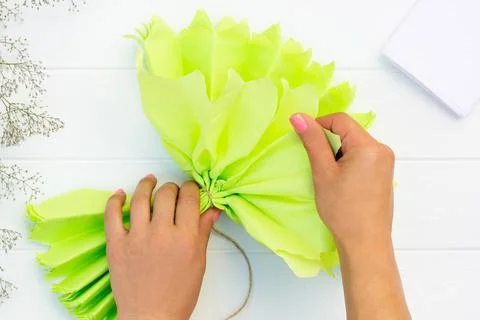 Step by step tutorial on making a light green fluffy pom-pom from tissue pape Stock Photos