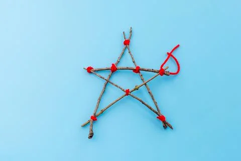 Step-by-step tutorial on making a star-shaped ornament from sticks and red .. Stock Photos