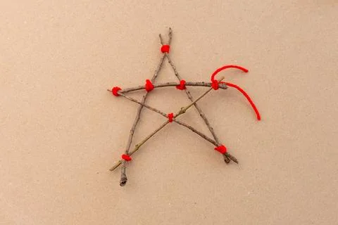Step-by-step tutorial on making a star-shaped ornament from sticks and red .. Stock Photos