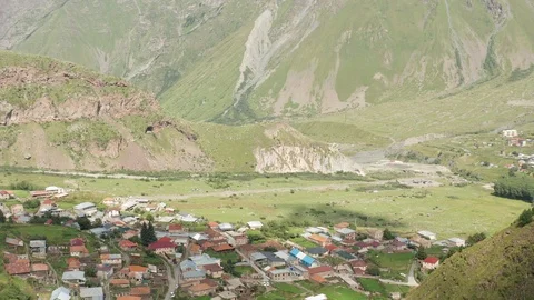 Stepantsminda Georgia Mountains of Kazbegi Structure Sits in Valley Revealed Stock Footage 115039737