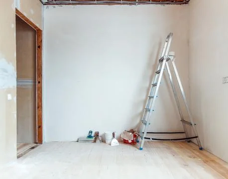 A stepladder with painting tools in a room. Preparing for putty Foto stock
