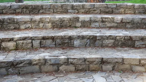 Stepped (raked) seating audience in a small outdoor amphitheater, made of stone Stock Footage 232344211