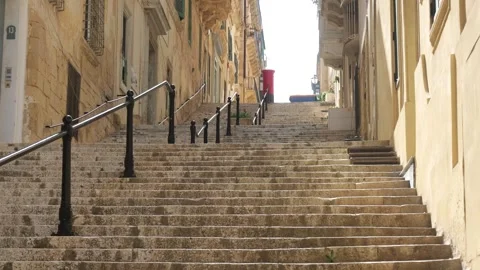 Stepped street descends through valletta narrow stairway a distant postbox Stock Footage 341805609