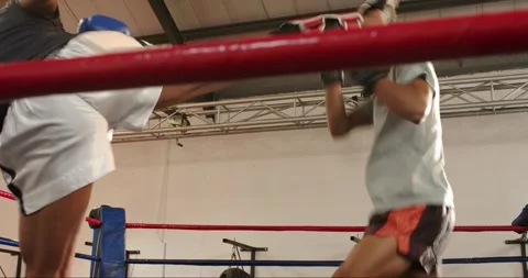 Stepping into boxing ring, two male sparring partners exchanging jabs and Stock Footage 336609066