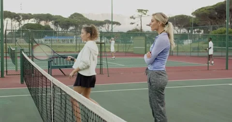 Stepping up female coach and trainees holding rackets, swinging forehands for Stock Footage 340968540