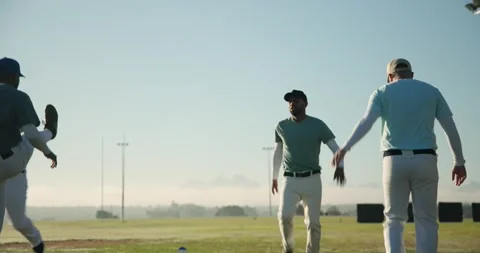 Stepping forward diverse baseball teammates warming knees at cones on field at Stock Footage 342594961