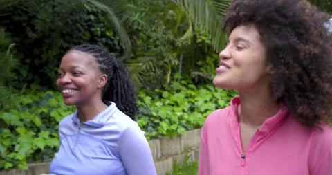Stepping onto garden path, Diverse female friends in athletic tops chatting and Stock Footage 341393471