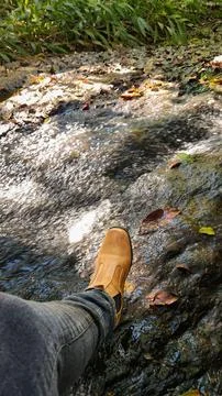 Stepping into the river with boots Stock Photos