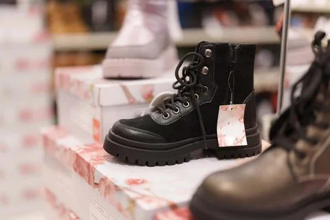 Stepping into Style boots displayed on boxes inside a brightly lit store in.. Stock Photos
