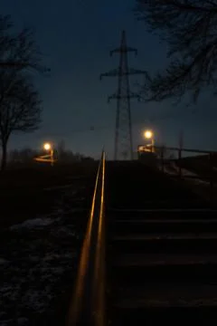 The steps are up, the railing is illuminated by an orange street lamp. Evenin Stock Photos