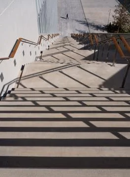 Steps down, crossed by shadows, on a sunny day at the Stavros Niarchos Center Stock Photos