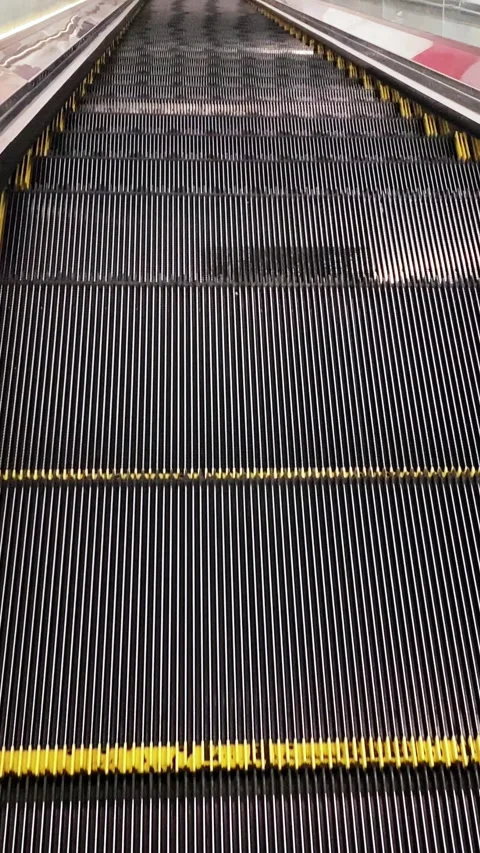 The steps of an empty escalator move up close up view from above Stock Footage 268042976