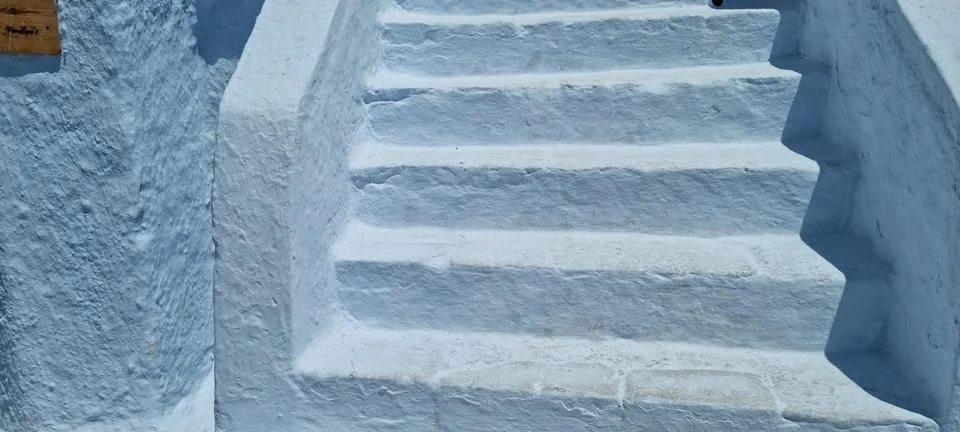 Steps lead to a bright place with white walls and sunlight shining down on .. Stock Photos