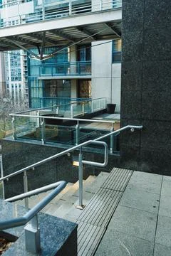Steps lead down to a modern building with glass elements and a landscaped a.. Photos