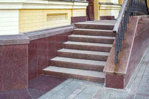 Steps leading up to a threshold building of granite stairs with railing. Stock Photos