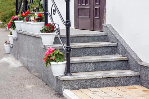 Steps leading up to a threshold building of granite stairs with railing. Stock Photos