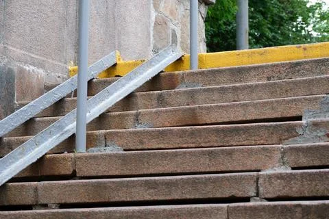 Steps leading to a yellow-lined pathway in a quiet park setting Stock Photos