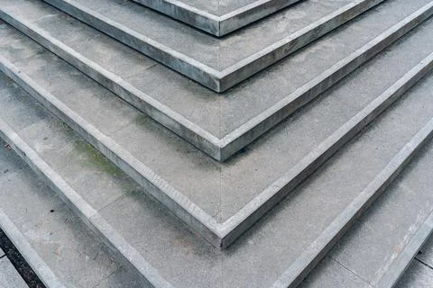 Steps made of gray stone arranged in layers create a pattern in the urban Stock Photos