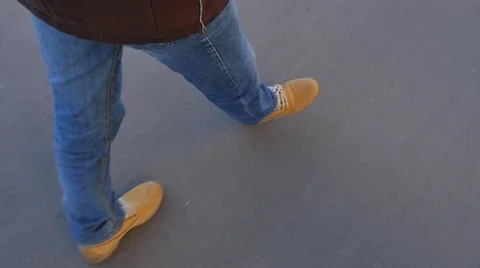 Steps of a man walking in yellow boots. Slow motion Stock Footage 48585186