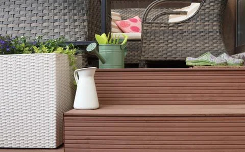 Steps to patio. Backyard. Tools in garden. Summer and wicker furniture. Stock Photos