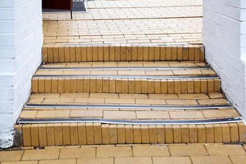 Steps with rubber non-slip strips on the arch staircase at the entrance. Stock Photos