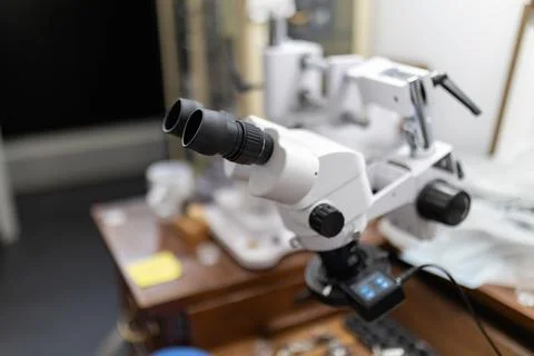 Stereo microscope on workbench magnifying details for precision work Stock Photos