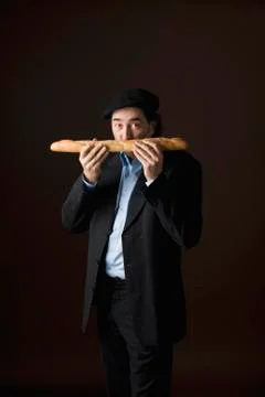 Stereotypical french man smelling a baguette Stock Photos