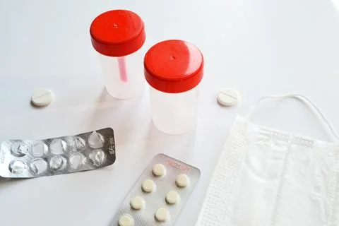 Sterile transparent empty plastic container for analysis, pills, medical mask Stock Photos