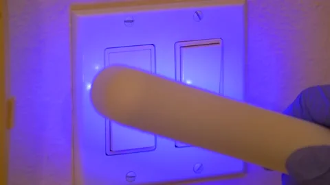 Sterilizer with UV C light used on light switches for coronavirus cleanup, Close Stock Footage
