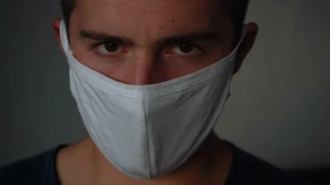 Stern man in a mask looking at the camera Video stock 136485521