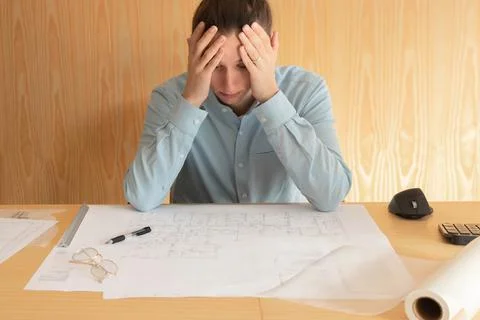 Stess, overwork and tired young architect working on project at home office Stock Photos