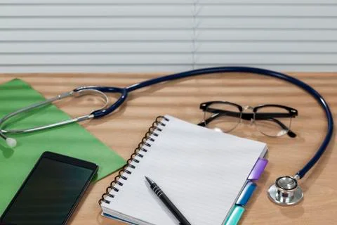 Stethoscope and a notepad laying on a doctors desk Stock Photos