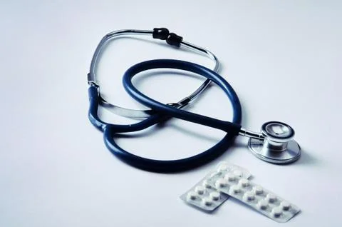 Stethoscope and some pills - isolated on a white background Stock Photos