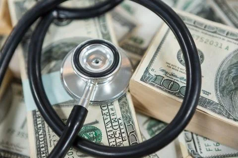 Stethoscope on bundle of currency note Stock Photos