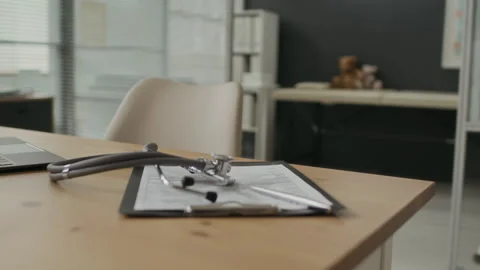 Stethoscope on Clipboard Resting on Desk in Empty Pediatrician Office Stock Footage 339783658